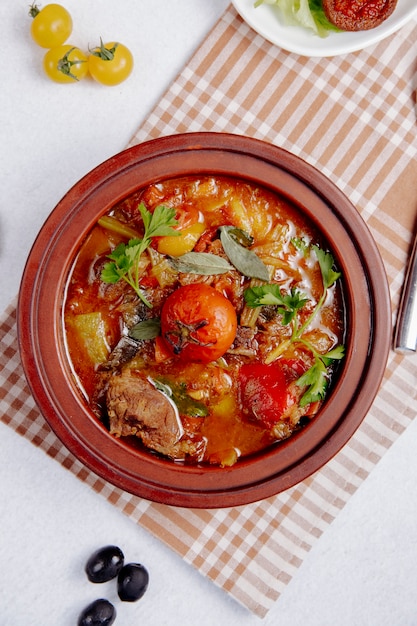 Free Photo  stewed meat with potatoes and tomatoes in a clay pot