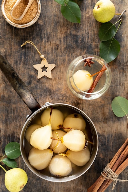 STEWED PEARS pot of sweet pears stewed in syrup or white wine on a green wooden table The cooking process