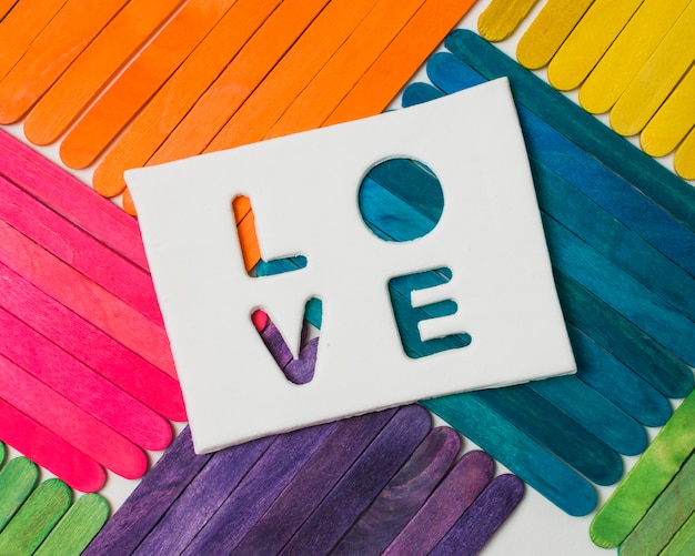 Free photo sticks in bright lgbt colors and love word on tablet