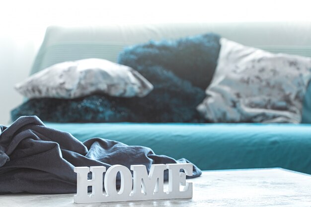 Still life in blue tones, with wooden inscription home and decorative elements in the living room.