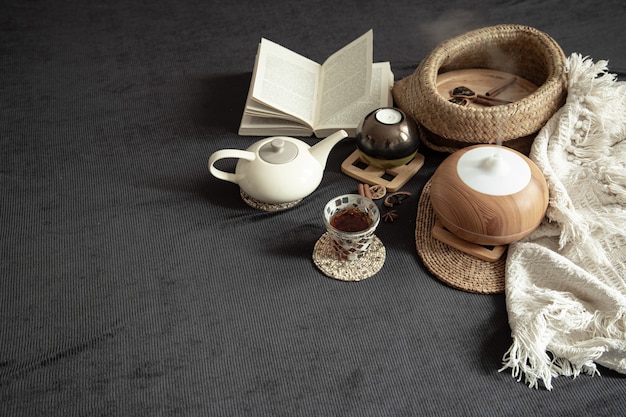 Free photo still life cozy house with decorative details in the interior . household items and comfort. candles and a book lie on the bed in the living room.