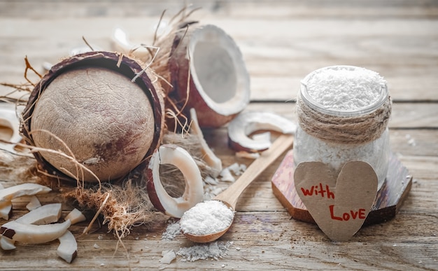 Still life Valentines day with coconut and heart, wooden spoons with coconut on wooden background