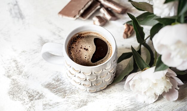 Still life with a cup of coffee and flowers