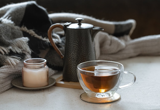 Still life with a cup of tea, a teapot, a book and decor details