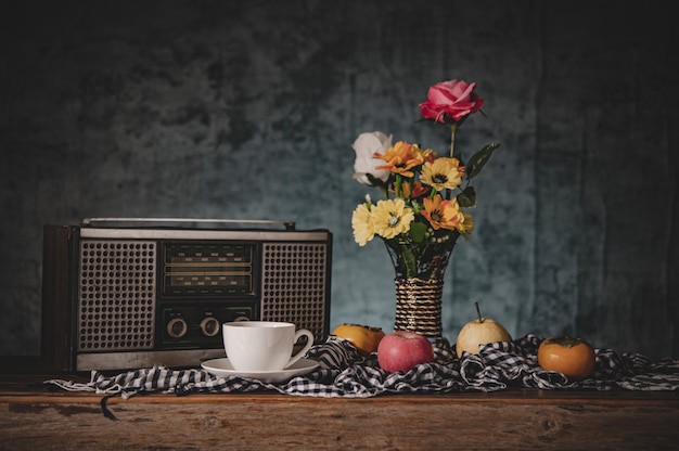 Free Photo still life with flower vases with fruits and retro radio