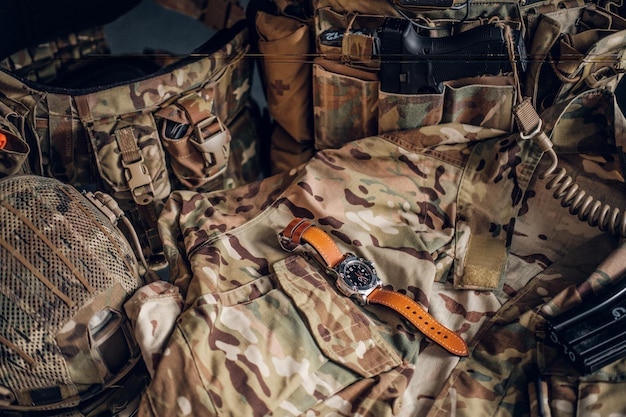 Free photo still life with nice watch and military uniform with typical camo pattern.