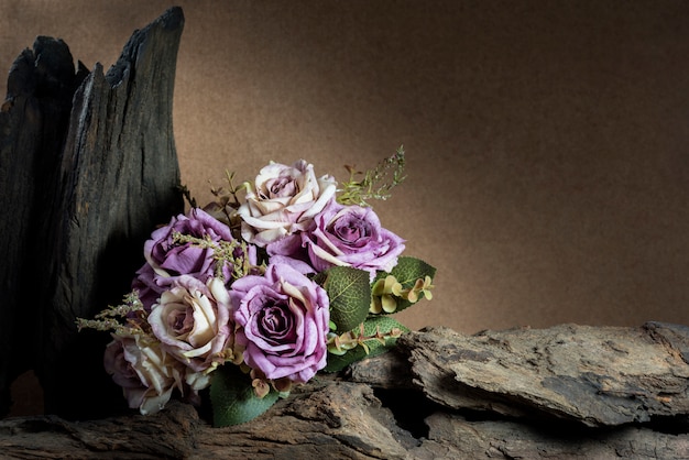 Free photo still life with purple roses and timber