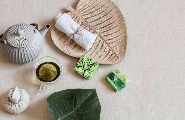 Still life with soap, towel, leaf and green tea. Health and beauty concept.