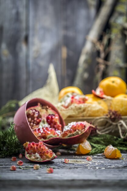 still life with tangerines and pomegranate on wood