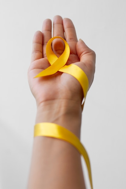 Free Photo still life of yellow ribbon in hand