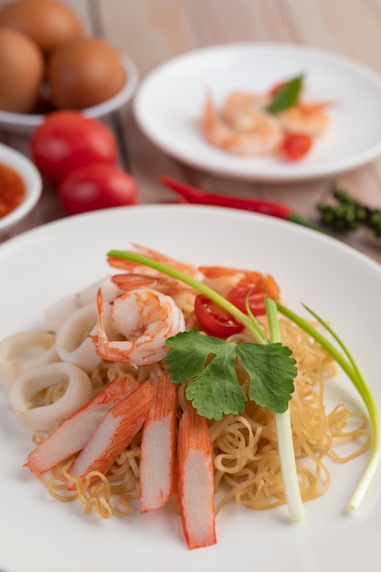 Free Photo stir-fried instant noodle with prawn and crab stick along  in a white dish.