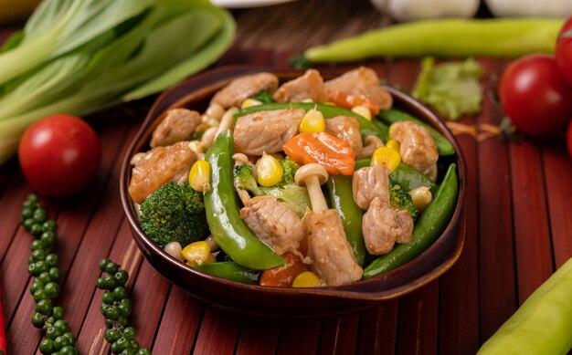 Stir-fried mixed vegetables containing Green peas, carrots, mushrooms, corn, broccoli, and pork