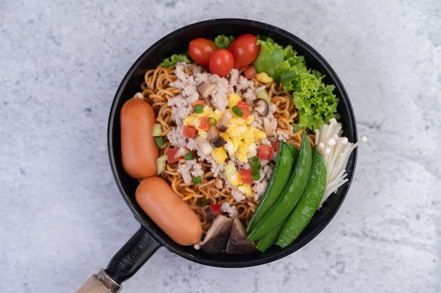 Free photo stir-fried noodles with minced pork, edamame, tomatoes and mushrooms in a pan.