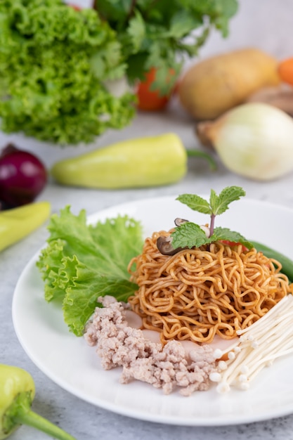 Free Photo stir-fried noodles with minced pork, edamame, tomatoes and mushrooms in a white plate.