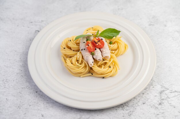 Stir-fried spaghetti and pork, beautifully arranged in a white plate.