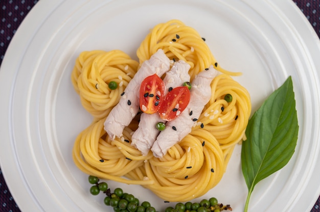 Stir-fried spaghetti and pork, beautifully arranged in a white plate.