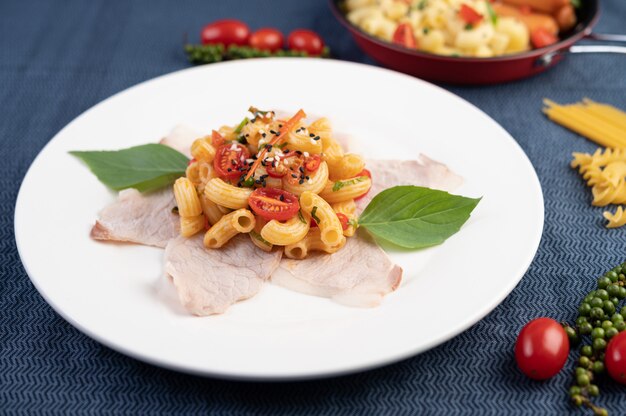 Stir-fry macaroni on top pork roughly in a white plate.