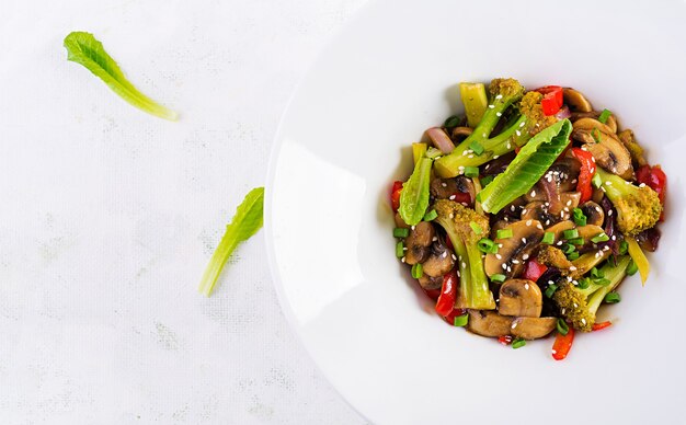 Free photo stir fry vegetables with mushrooms, paprika, red onions and broccoli. healthy food. asian cuisine. top view, overhead