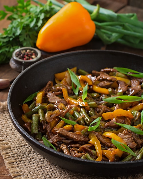 Stir frying beef with sweet peppers and green beans