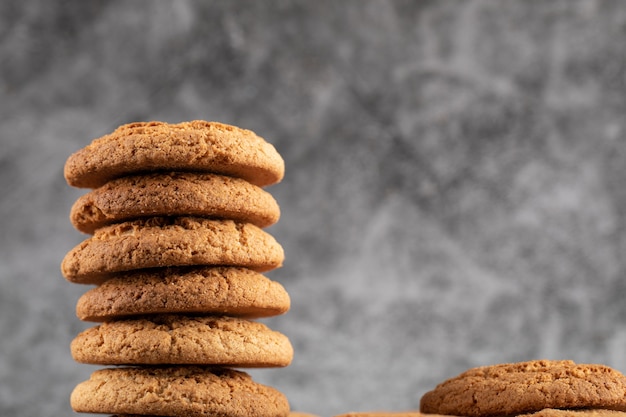 A stock of oatmeal cookies on grey concrete.