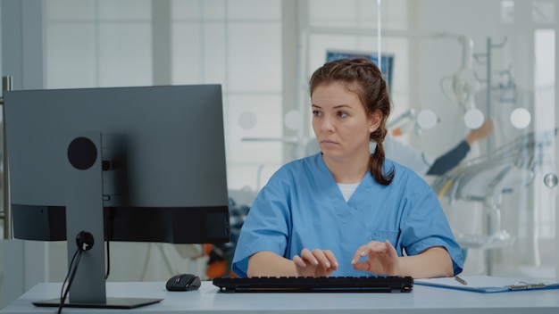 Stomatological assistant typing on computer keyboard