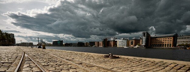 stone road surrounded by buildings under a dark cloudy sky