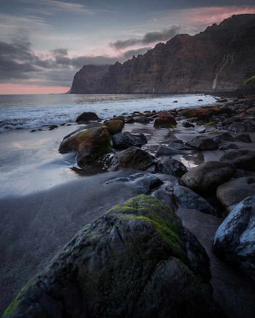 stones in the beach under the cloudy sky at sunset