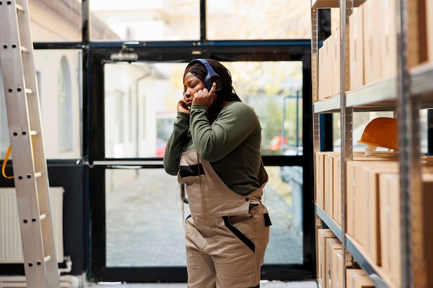 Free photo storage room manager wearing headphones listening music