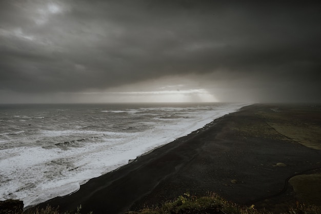 Free Photo storm reaching to a black sand beach