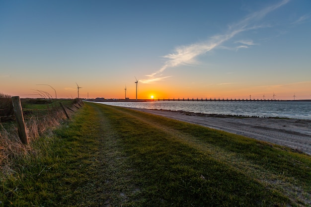 storm surge barrier and windmills in Zeeland province in the Netherlands on sunset