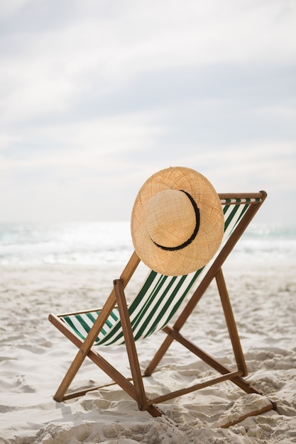 Free photo straw hat kept on empty beach chair