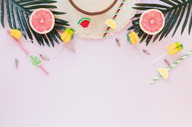 Free Photo straw hat with grapefruits and palm leaves