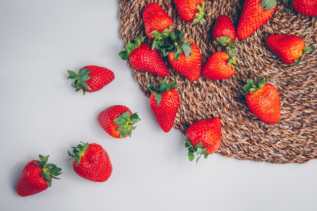 Strawberries on a trivet and white background. top view.