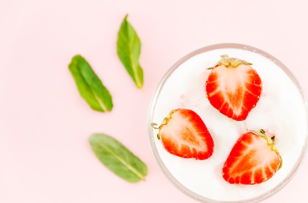 Strawberries with yogurt and green leaves 