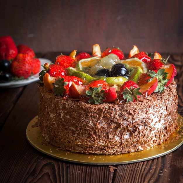 Strawberry, chocolate fruit cake and fresh strawberry on wooden table