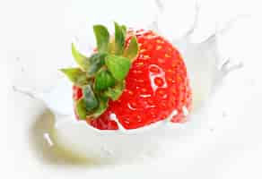 Free photo strawberry falling into milk