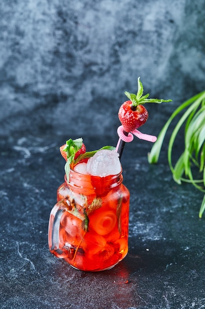 Free photo strawberry lemonade with ice, straw mint in the dark surface