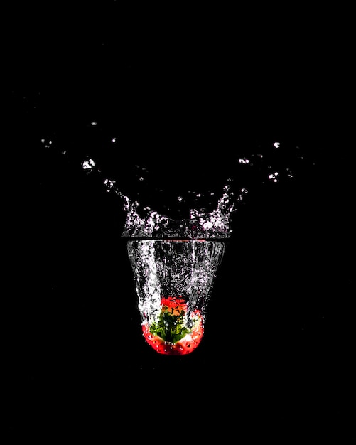 Free photo strawberry plunging into the water