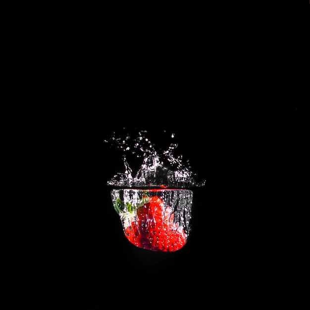 Free photo strawberry plunging into the water