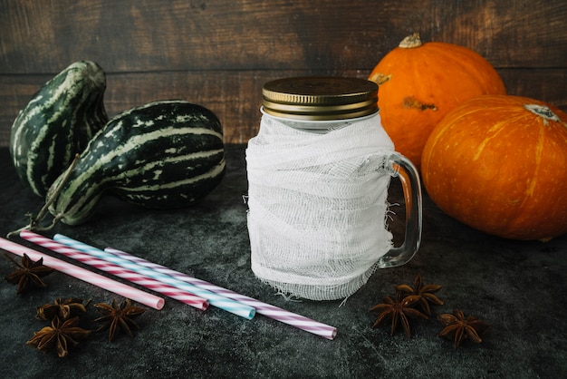 Straws and beverage near spice and pumpkins