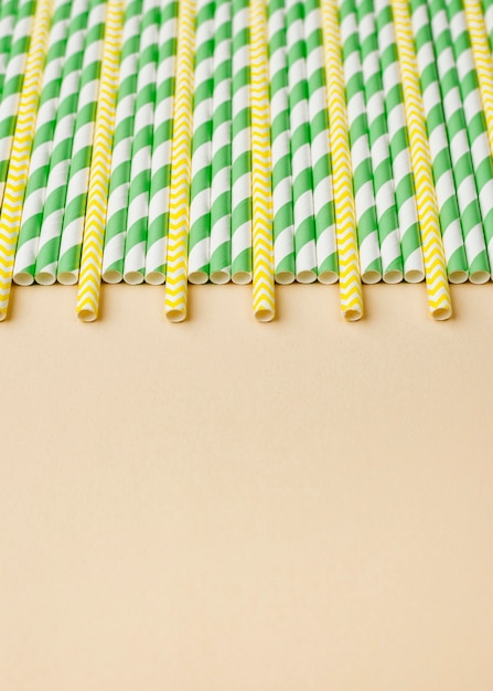 Free Photo straws in green and yellow colors copy space