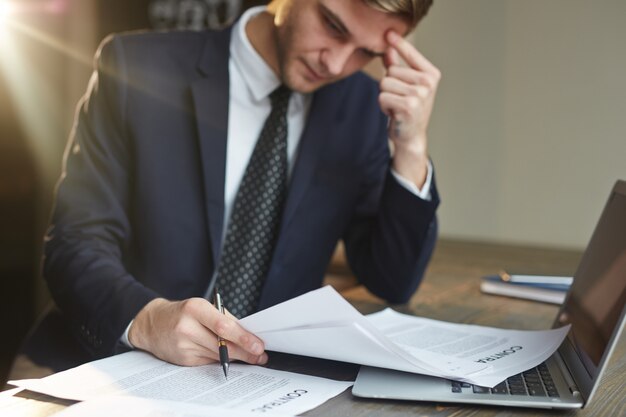 Stressed Businessman Working with Contract Documents