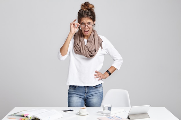 Free Photo strict female boss, looks angrily through glasses, going to shout