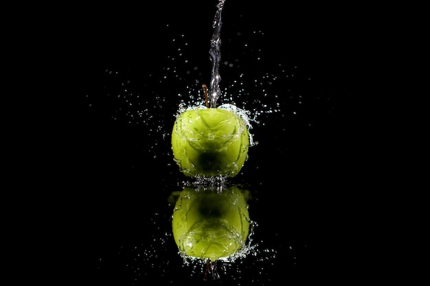 Free photo strim of water pours on green apple on black background