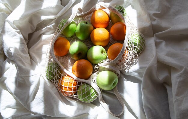 String bag with fruits in bed with sunbeams