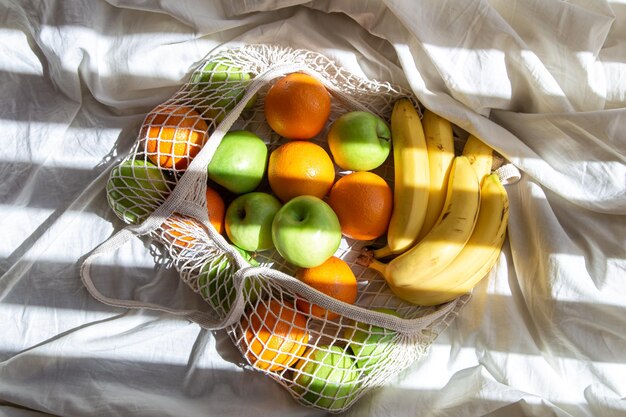 String bag with fruits in bed with sunbeams