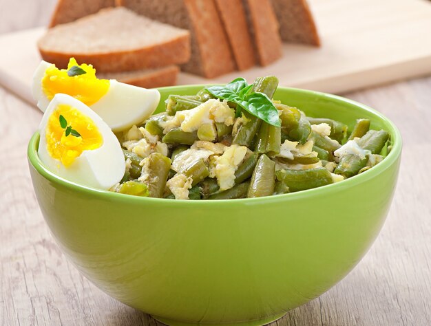 String beans with eggs in bowl.