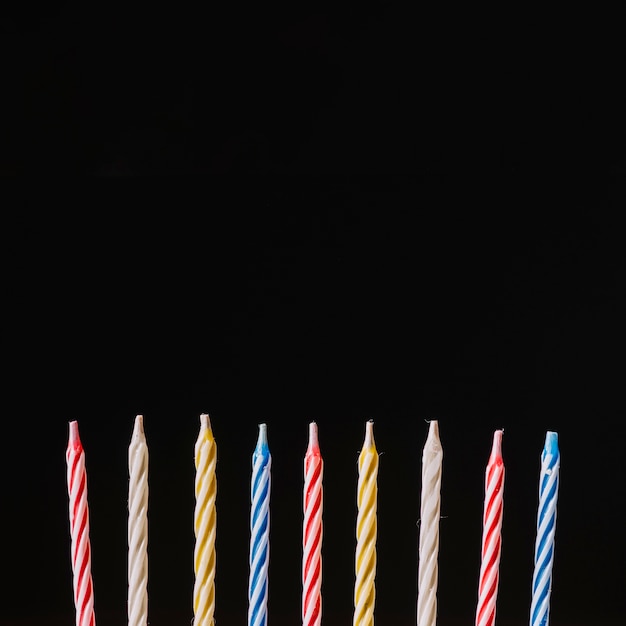 Striped colorful birthday candles against black background