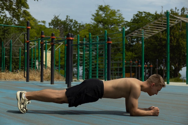 Free Photo strong athletic man doing exercises on sports field