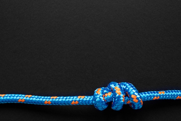 Free photo strong blue rope knot on black copy space background